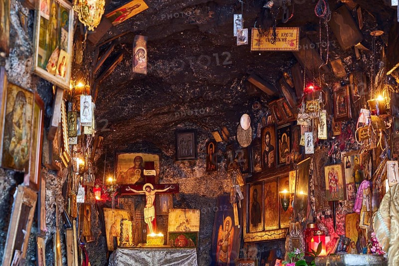 Rock Chapel, Archangel Michael Panormitits, Illuminated altar with a crucifix of Christ surrounded by icons and paintings in a cave, Old Town of Rhodes, Rhodes Town, Rhodes, Dodecanese, Greek Islands, Greece, Europe