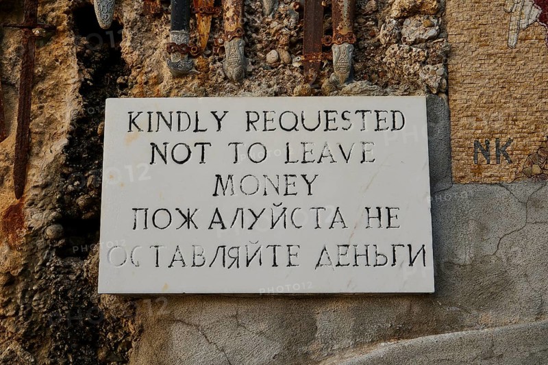 Rock Chapel, Archangel Michael Panormitits, A sign with the request not to leave money, in English and Russian language mounted on stone wall, Old Town of Rhodes, Rhodes Town, Rhodes, Dodecanese, Greek Islands, Greece, Europe