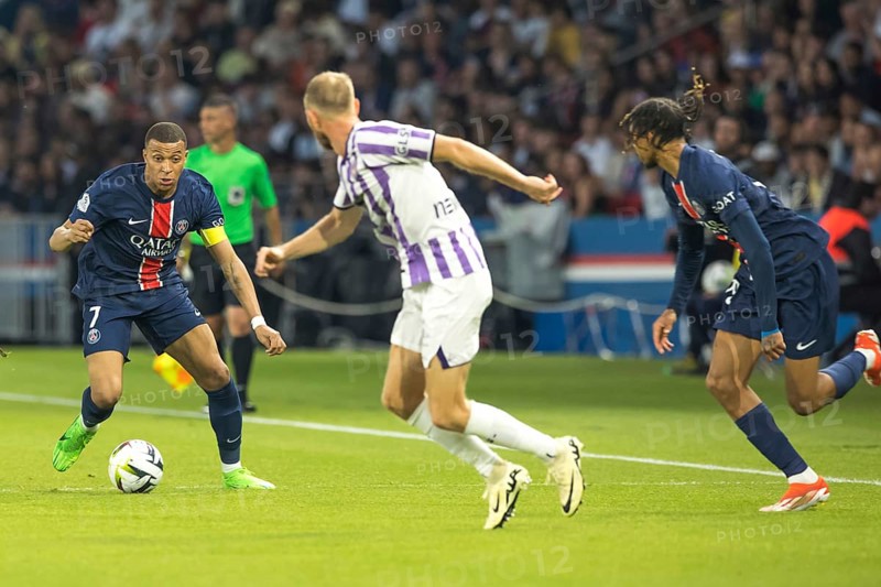 Football match, captain Kylian MBAPPE' Paris St. Germain left on the ball, a player of FC Toulouse and Bradley BARCOLA Paris St. Germain right watching him tensely while running, Parc des Princes football stadium, Paris, France, Europe