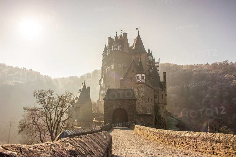 View of Eltz Castle. A landscape in autumn on a frosty morning with ripe and fog. The famous castle is in a valley and surrounded by forest from the 12th century in Wierschem, Rhineland Palatinate Germany
