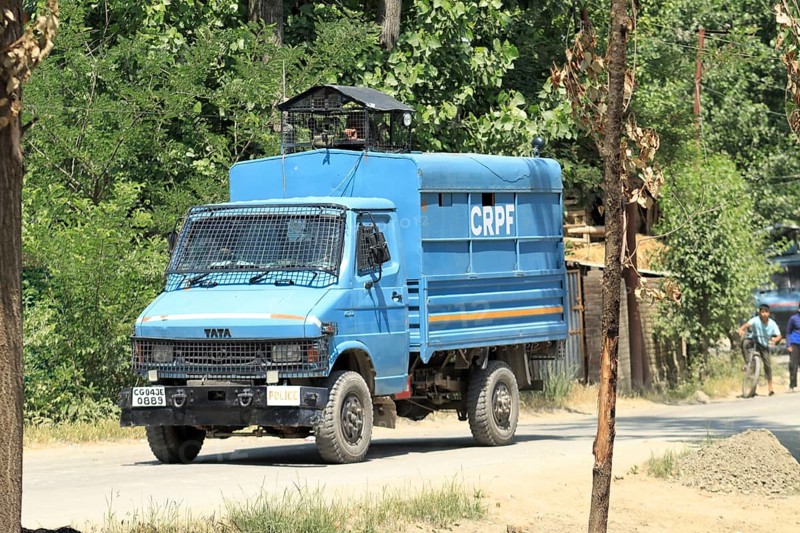 Blue police truck patrolling along a road lined with trees on a sunny day, Encounter, Pulwama, Jammu and Kashmir, India, Asia