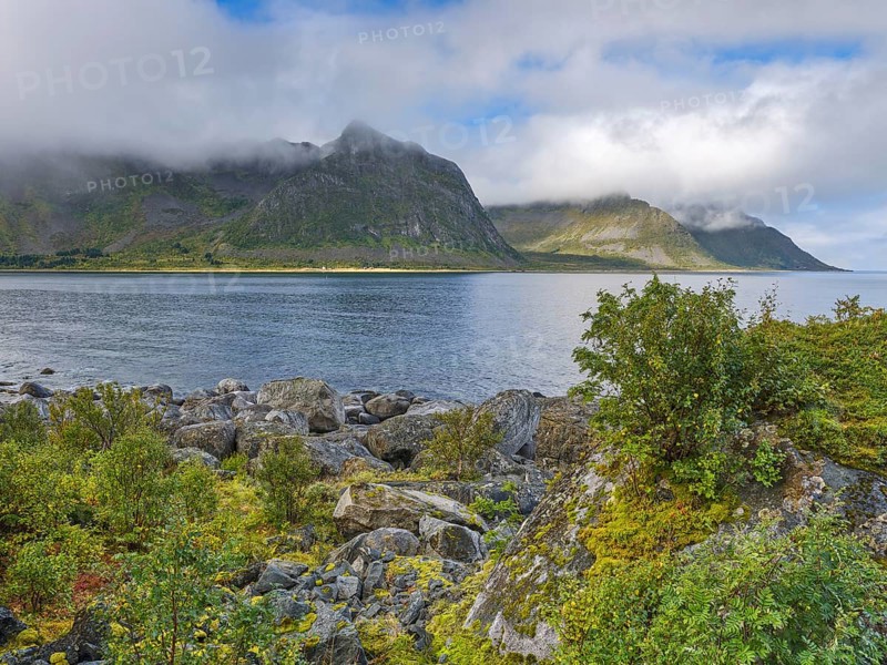 Rocky coast of Tungeneset, fog and blue sky, Senja, Norway, Europe