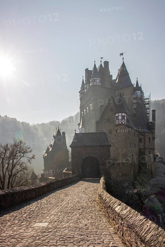 View of Eltz Castle. A landscape in autumn on a frosty morning with ripe and fog. The famous castle is in a valley and surrounded by forest from the 12th century in Wierschem, Rhineland Palatinate Germany