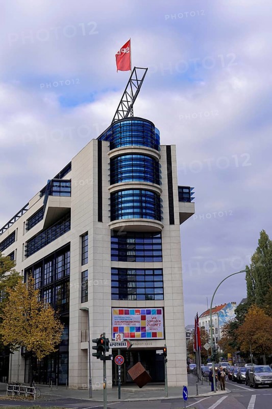 A modern office building on a street corner with a flag and autumnal trees, Willy-Brandt-Haus, SPD Headquarters, Berlin, Berlin, Germany, Europe