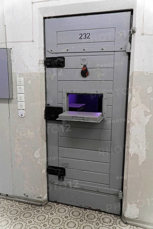 Close-up of a grey prison door with food window and security devices, Berlin-Hohenschoenhausen Memorial, former headquarters, Stasi remand prison, Berlin, Germany, Europe
