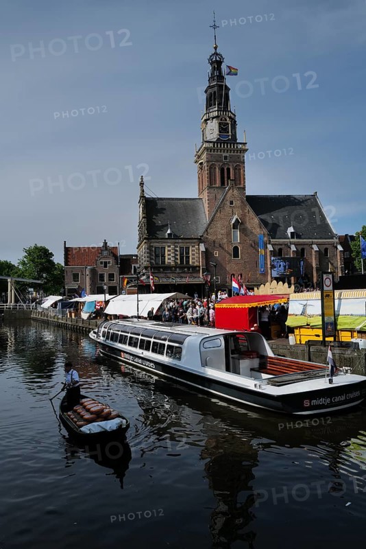 A cargo of cheese being transported down a canal next to a cheese market taking place in front of the famous Waaggebouw. Alkmaar, Netherlands