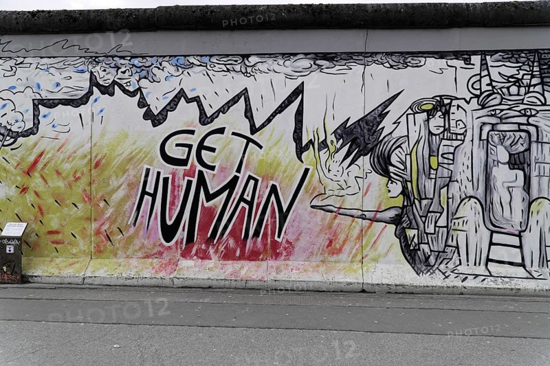 Graffiti on the Berlin Wall in the East Side Gallery, Berlin, Germany, Europe, A comic-like graffiti with the text 'GET HUMAN', a human figure and a dragon in a dynamic design, East Side Gallery, Warschauer Strasse, Europe