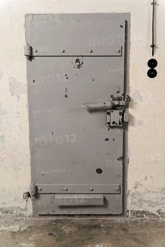 Solid grey metal cell door, firmly locked. Cool industrial aesthetics, Berlin-Hohenschoenhausen Memorial, former headquarters, Stasi remand centre, Berlin, Germany, Europe