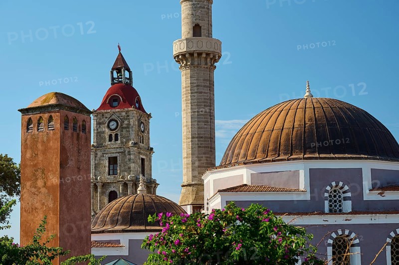 Suleiman Mosque, minaret and domes next to bell tower with red bricks, surrounded by flowers and historical architecture, Rhodes Old Town, Rhodes Town, Rhodes, Dodecanese, Greek Islands, Greece, Europe