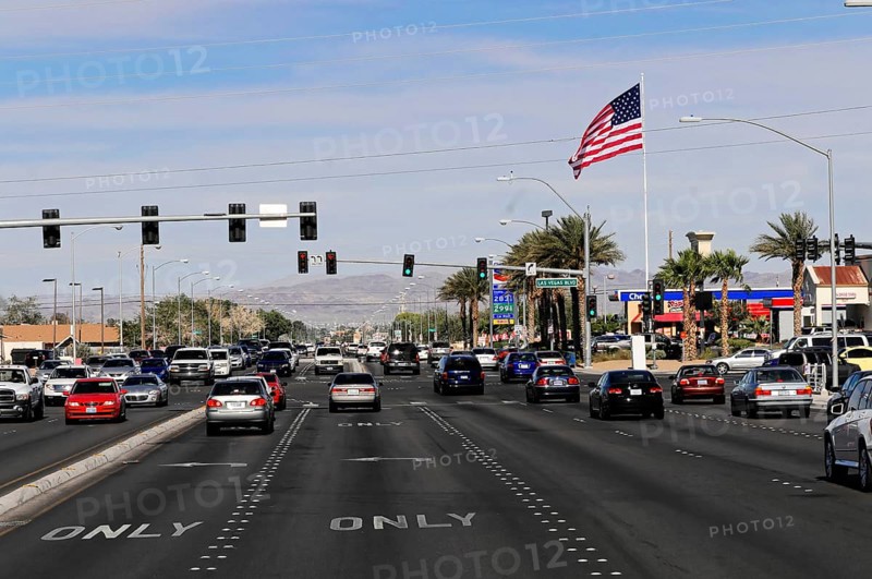 Las Vegas, Nevada, USA, North America, A busy street with cars, an American flag and shops in the background, Las Vegas Strip, North America