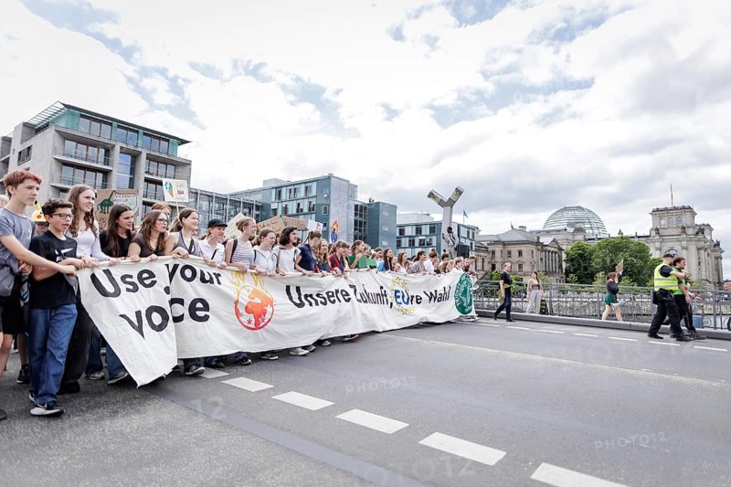 Demonstrators with signs at Fridays for Future in front of the Reichstag building, taken during the climate strike for the EU elections in Berlin, 31 May 2024