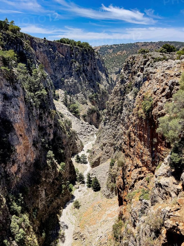 View to the south-west from bridge over deep narrow Aradena gorge to steep rugged rocks, at the bottom of the picture hiking trail through Aradena gorge, Aradena, Crete, Greece, Europe