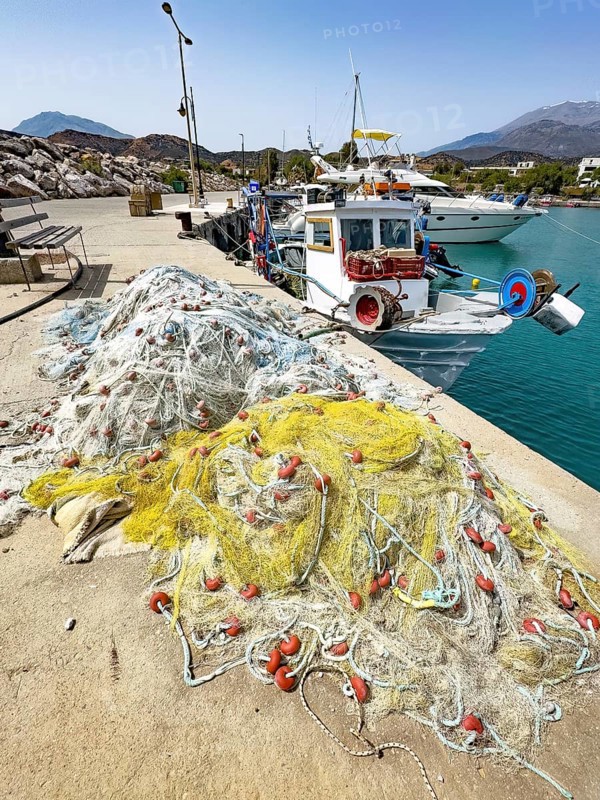 In front fishing nets nets of fishermen behind moored fishing boat moored to quay wall in harbour of Kokkinos Pyrgos, Kokkinos Pyrgos, Crete, Greece, Europe