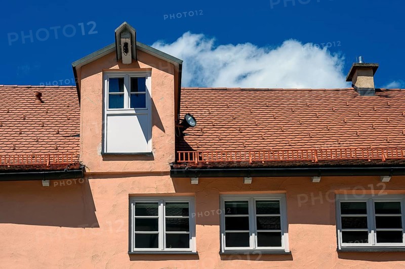 Red facade and tiled roof with crane dormer in the Muehlberg ensemble is a heritage-protected group of late medieval houses, Kempten, Allgaeu, Bavaria, Germany, Europe