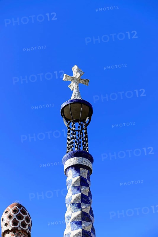 Antoni Gaudi, Park Guell, UNESCO World Heritage Site, Barcelona, Catalonia, Spain, Europe, Decorative tower with cross and mosaic details in front of a clear blue sky, Europe