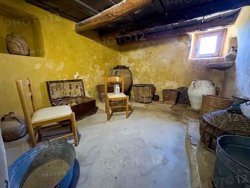 Historic small living room cell of monk Monk's cell with baskets and chairs in UNESCO World Heritage Site Orthodox Monastery Moni Arkadi Arkadi Monastery from early Middle Ages, important national monument National Shrine on the island of Crete, Arkadi, Armnatos, Crete, Greece, Europe