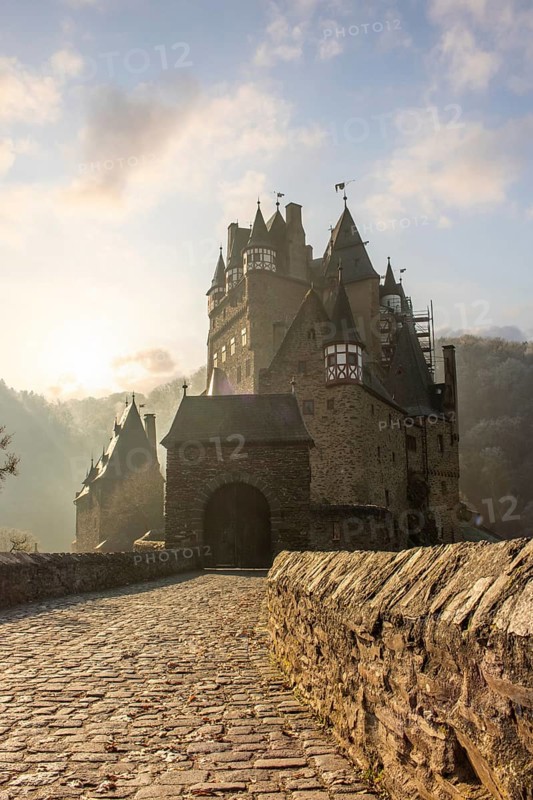 View of Eltz Castle. A landscape in autumn on a frosty morning with ripe and fog. The famous castle is in a valley and surrounded by forest from the 12th century in Wierschem, Rhineland Palatinate Germany