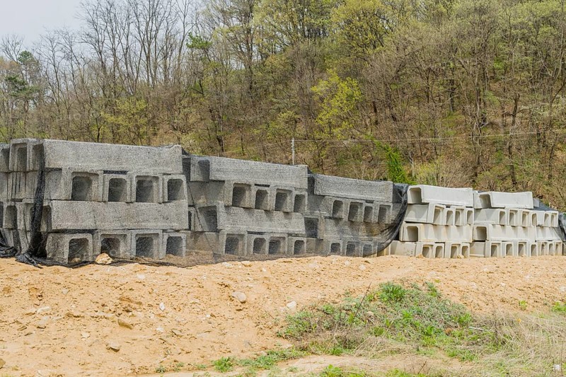 Concrete square culvert sections at base of hillside at rural construction site in Daejeon, South Korea, Asia