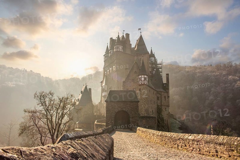 View of Eltz Castle. A landscape in autumn on a frosty morning with ripe and fog. The famous castle is in a valley and surrounded by forest from the 12th century in Wierschem, Rhineland Palatinate Germany