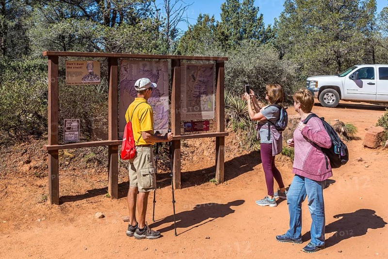 Woman takes photo of trail map before starting a hike in Sedona, Arizona, USA, North America