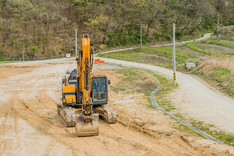 Front view of backhoe parked at rural construction site in Daejeon, South Korea, Asia