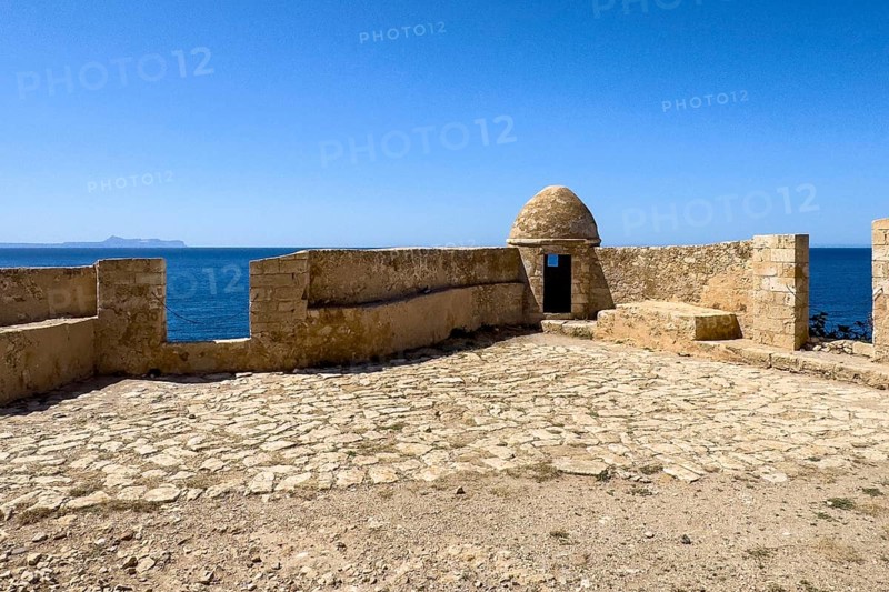 Round watchtower and wall with crenellated gap for guns one of 10 round watchtowers of historic fortress Fortetza Fortezza of Rethymno built by Republic of Venice in 16th century in northwest of old town of Rethymno on rocky hill Paleokastro on north coast of island Crete, in background Aegean Sea Aegean Cretan Sea Mediterranean, Rethymno, Crete, Greece, Europe