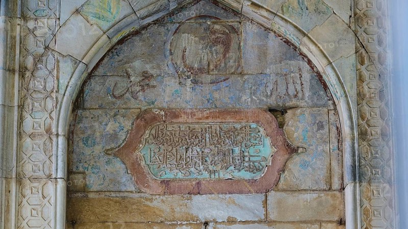 Opposite Retzep Pasha Mosque, Arabic inscription plaque, stone wall with artistic engravings and inscriptions in faded colours with historical details, Rhodes Old Town, Rhodes Town, Rhodes, Dodecanese, Greek Islands, Greece, Europe