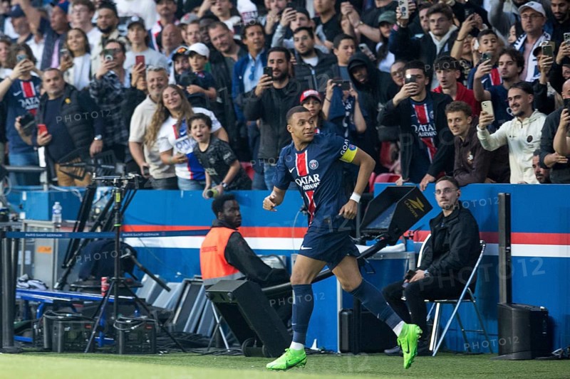 Football match, captain Kylian MBAPPE' Paris St. Germain left has just scored the 1:0 for Paris St. Germain, just cheering with the substitutes he runs past the fans, the fans take advantage of the moment and photograph him from behind, Parc des Princes football stadium, Paris, France, Europe
