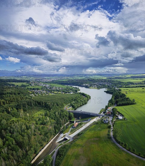 The Malter Dam is a dam built between 1908 and 1913 in the Free State of Saxony near the town of Malter, which impounds the middle reaches of the Rote Weisseritz. The dam is a curved gravity dam made of quarrystone masonry according to the Intze principle. It is an important element in flood protection up to the Elbe. Due to the current weather conditions, additional water is being drained off. Heavy rain showers and continuous rain are advancing from the Ore Mountains in the sky, Malter, Saxony, Germany, Europe