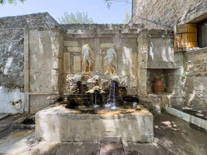Venetian fountain depicting weathered relief of Adam and Eve in front of the Tor tor of Eastern Orthodox Monastery of Ayios Antonios Vrontisi Vrondisi Vrontissiou Monastery from early Middle Ages dedicated to Saint St Anthony, Zaros, Crete, Greece, Europe
