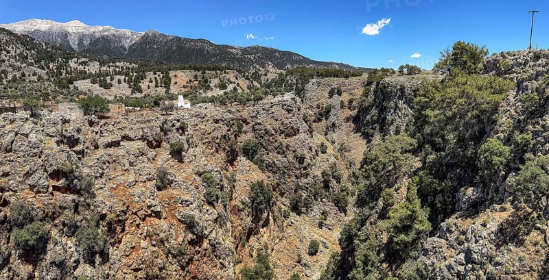 View to the northeast from bridge over Aradena gorge to rocks of Aradena gorge, small restored church of abandoned village Aradena in the background, Aradena, Crete, Greece, Europe