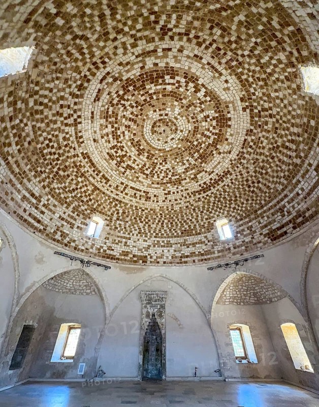 View of interior of domed building former Sultan Ibrahim Mosque with mosaic ceiling in dome built 1646 after Ottoman conquest of Crete at former site of Venetian bishop church San Nicolo in ruins fortress ruins of historic fortress Fortetza Fortezza of Rethymno built by Republic of Venice in 16th century. century in northwest of old town of Rethymno on rocky hill Paleokastro on north coast of island Crete, Rethymno, Crete, Greece, Europe