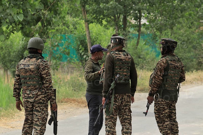 Soldiers in camouflage uniforms talking on a road, with weapons and gear visible, Encounter, Pulwama, Jammu and Kashmir, India, Asia