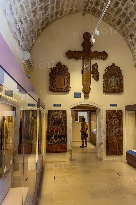 Entrance area with showcases and large wooden cross on wall in vaulted museum Monastery museum in UNESCO World Heritage Site orthodox monastery Moni Arkadi Arkadi monastery from early Middle Ages, important national monument national shrine on island of Crete, Arkadi, Armnatos, Crete, Greece, Europe