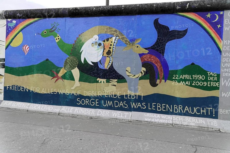 Graffiti on the Berlin Wall in the East Side Gallery, Berlin, Germany, Europe, Cheerful wall art with cartoon animals, a rainbow and a message of peace calling for care for planet Earth, East Side Gallery, Warschauer Strasse, Europe