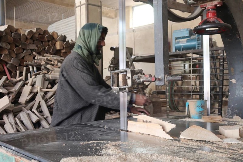 Man working in a wood workshop with machinery and logs around, wearing traditional clothing, kashmiri willow, bat manufacturing, Jammu and Kashmir, India, Asia