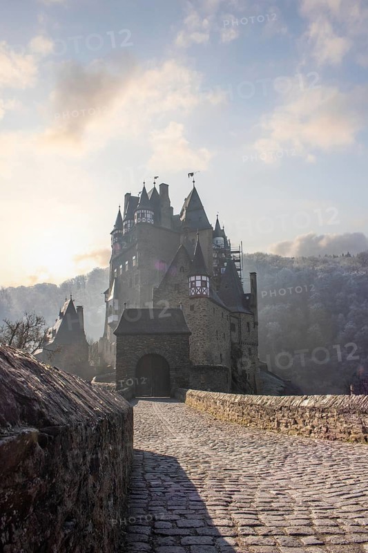 View of Eltz Castle. A landscape in autumn on a frosty morning with ripe and fog. The famous castle is in a valley and surrounded by forest from the 12th century in Wierschem, Rhineland Palatinate Germany
