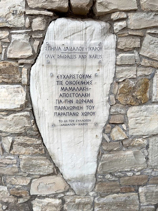 Tourist information about the cave hideout of Daedalus and Icarus in Greek on the cliff above the harbour of Agia Galini on the south coast of Crete, Agia Galini, Crete, Greece, Europe