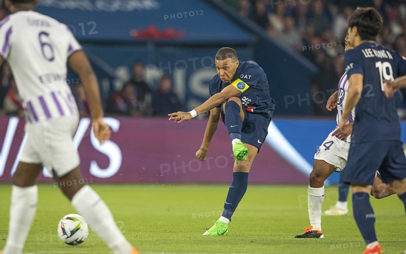 Football match, captain Kylian MBAPPE' Paris St. Germain centre with volley shot past opponent Logan COSTA FC Toulouse left, right Kang-in LEE Paris St. Germain can be seen from behind, Parc des Princes football stadium, Paris, France, Europe
