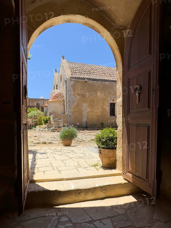 View through door Tor tor archway archway on back of two-aisled church building church monastery church dedicated to Saints Constantine and Helen and Transfiguration Christ the Saviour of Arkadi Monastery with double apse built 1587 to 1600 double apse of UNESCO World Heritage Site Orthodox Monastery Moni Arkadi Arkadi Monastery from early Middle Ages, important national monument national shrine on Crete island, Arkadi, Armnatos, Crete, Greece, Europe