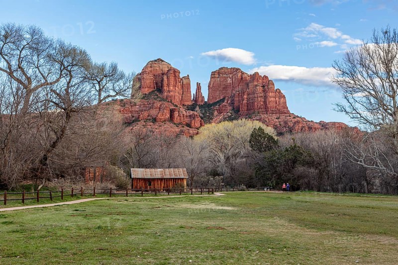 Cathedral Rock sandstone formations tower over a rustic barn at the Crescent Moon Picnic Site in Sedona, Arizona, USA, North America
