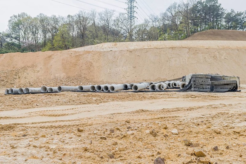 Concrete culvert pipes at base of dirt hillside at rural construction site in Daejeon, South Korea, Asia
