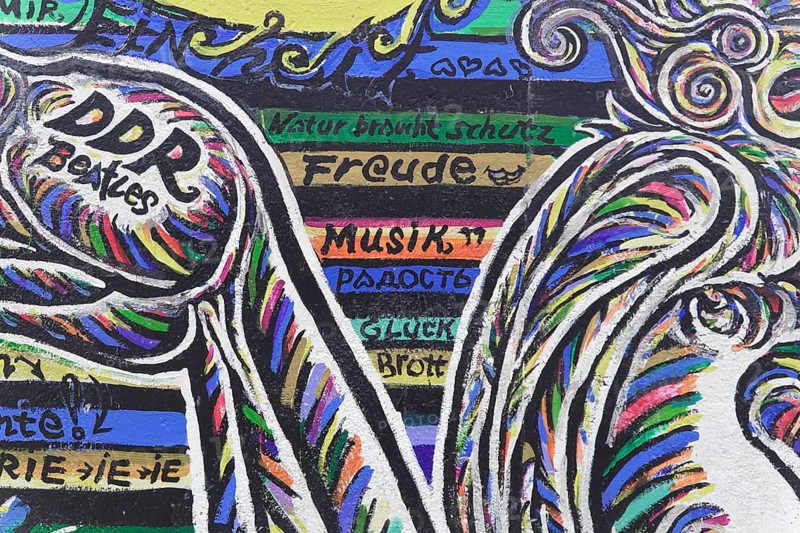Graffiti on the Berlin Wall in the East Side Gallery, Berlin, Germany, Europe, Colourful graffiti on a wall containing various texts and words surrounded by rainbow colours, East Side Gallery, Warschauer Strasse, Europe
