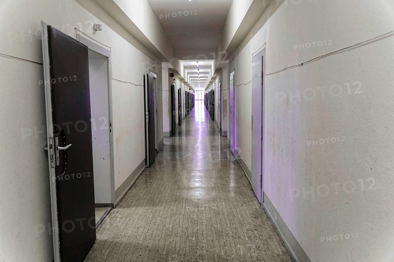 A long corridor with open grey doors and neon lighting in an old building, Berlin-Hohenschoenhausen Memorial, former headquarters, Stasi remand prison, Berlin, Germany, Europe