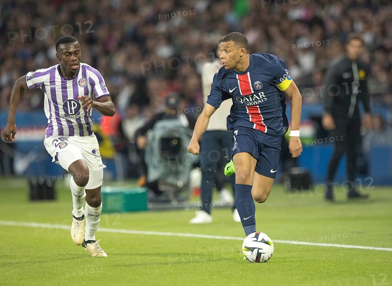 Football match, captain Kylian MBAPPE' Paris St. Germain running on the ball looking left, Kevin KEBEN FC Toulouse left following him, Parc des Princes football stadium, Paris, France, Europe