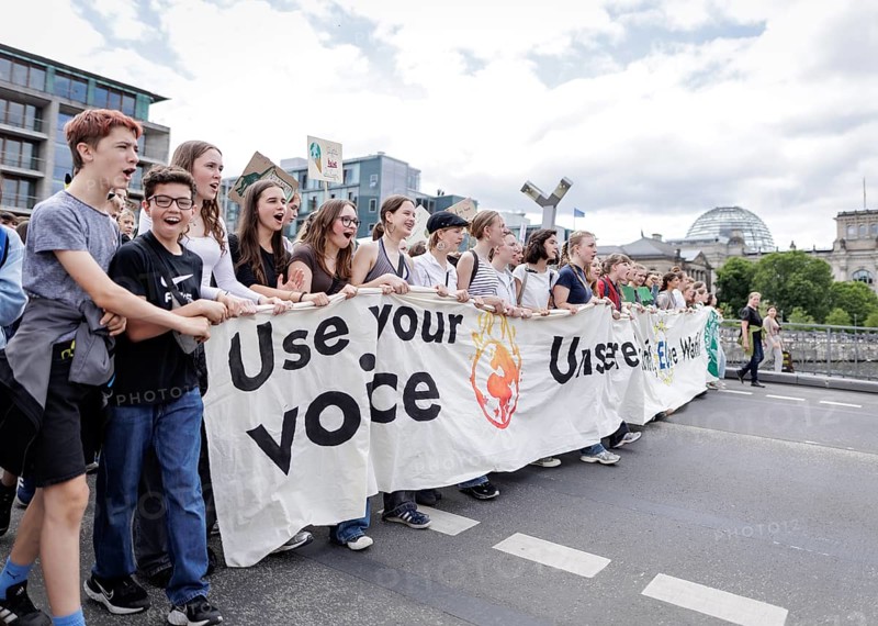 Demonstrators with signs at Fridays for Future in front of the Reichstag building, taken during the climate strike for the EU elections in Berlin, 31 May 2024