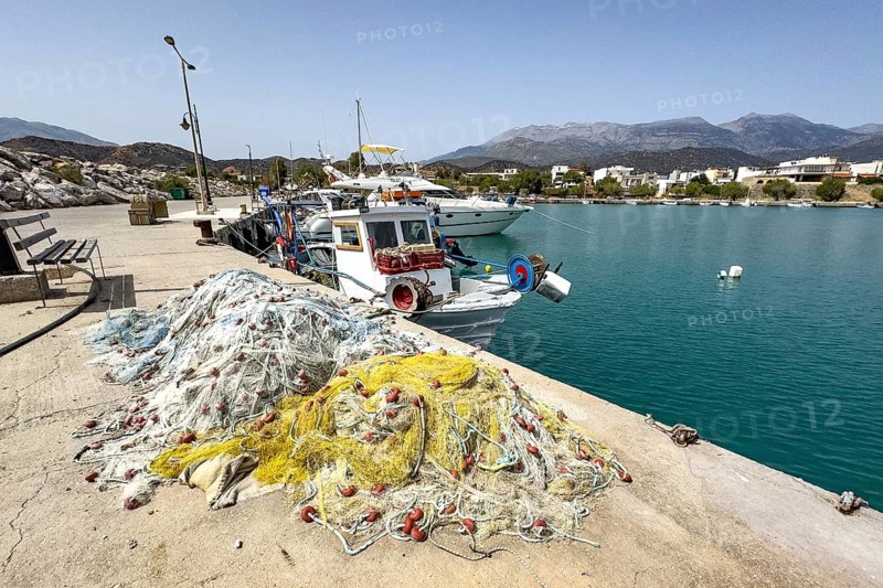 In front fishing nets nets of fishermen behind moored fishing boat moored to quay wall in harbour of Kokkinos Pyrgos, Kokkinos Pyrgos, Crete, Greece, Europe