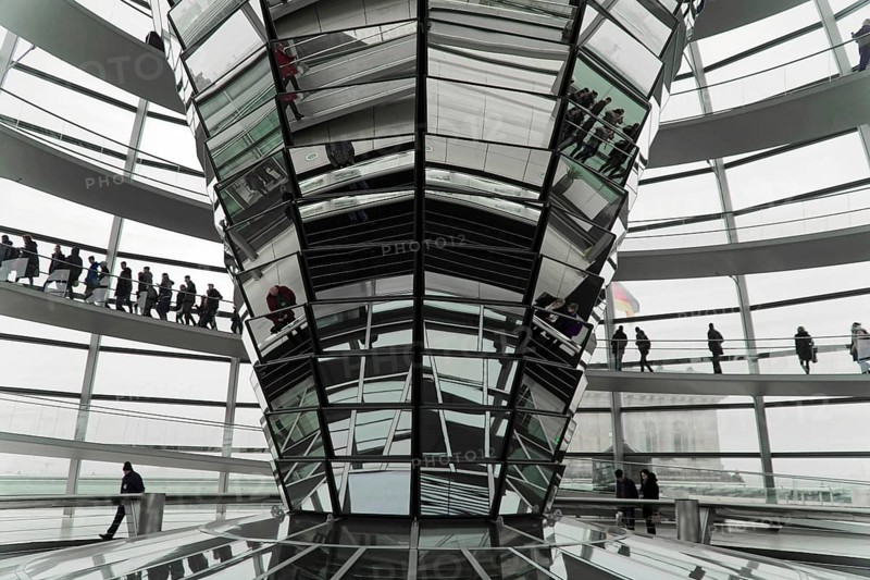 The dome of the Reichstag in Berlin. The architect Sir Norman Foster designed the steel and glass structure. Berlin, Berlin, Germany, Europe, people move through an imposing, modern glass construction with reflective surfaces, the dome of the Berlin Reichstag. Berlin, Europe