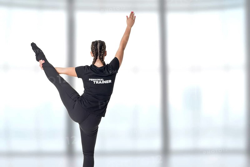Personal Trainer standing with one leg up in a gym