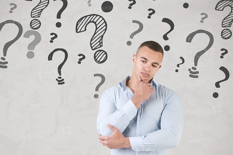 Man wondering with question marks around him
